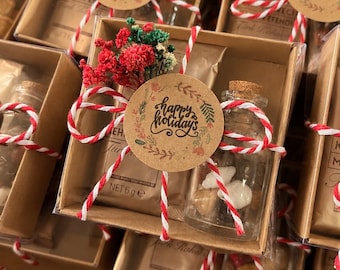 May include: A gift set in a brown cardboard box containing a small packet of Kurukahveci Mehmet Efendi Turkish coffee and a glass vial with a cork stopper filled with small stones, tied with red and white twine and a Happy Holidays tag.