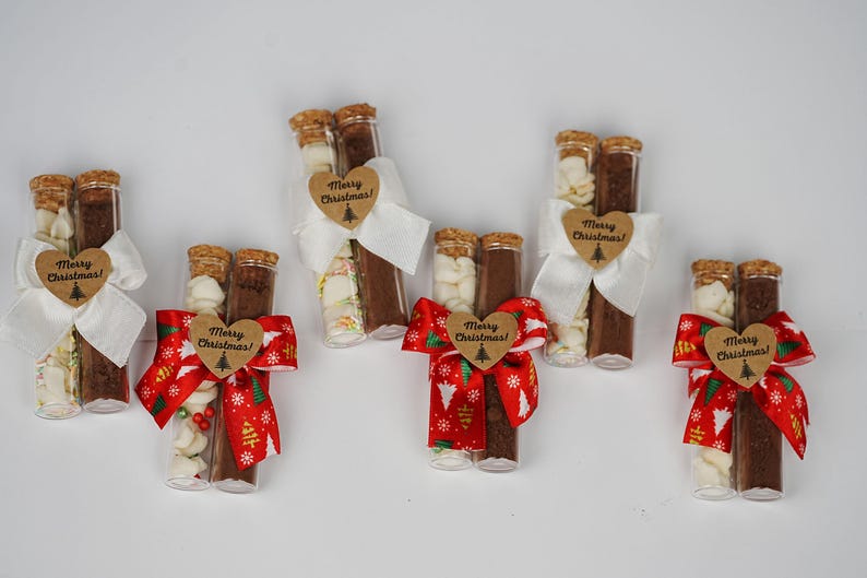 May include: Six glass test tubes filled with white and brown ingredients, tied together with red and white ribbon and a brown heart-shaped tag that says "Merry Christmas!"