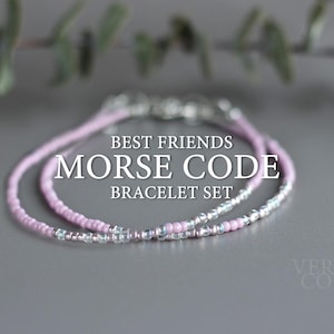 Puede incluir: Dos pulseras de cuentas, una rosa y otra plateada, con el texto "Best Friends Morse Code Bracelet Set" sobre un fondo gris.