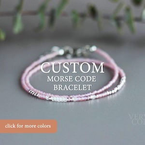 May include: A delicate pink and silver beaded bracelet with a clasp. The bracelet is layered with two strands of beads and has the text "CUSTOM MORSE CODE BRACELET" printed below it.