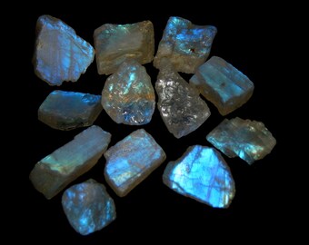 May include: A collection of iridescent labradorite crystals in various shapes and sizes. The crystals are a light blue color with a shimmery, iridescent sheen.