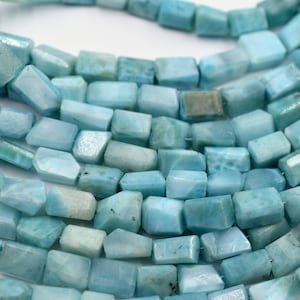 Könnte beinhalten: Eine Strähne aus hellblauen Edelsteinperlen, jede Perle ist facettiert und hat eine rechteckige Form.