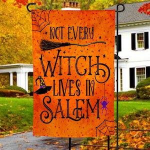 May include: Orange Halloween garden flag with black text that reads "Not every witch lives in Salem". The flag features a black witch's hat, a broom, a spider, and a spider web.