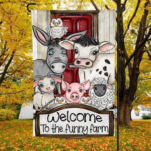May include: A colorful garden flag with a red barn door and a variety of farm animals, including a donkey, cow, goat, pig, and sheep. The flag reads "Welcome to the funny farm".