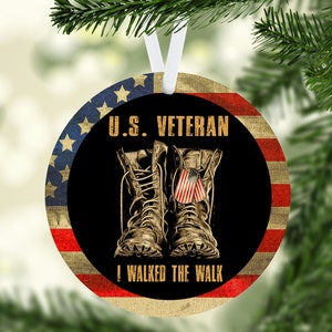 Pu&ograve; includere: Un ornamento rotondo a forma di bandiera americana rosso, bianco e blu con sfondo nero. L'ornamento presenta un paio di stivali di cuoio marroni con una piccola bandiera americana sul lato. Il testo "U.S. VETERAN I WALKED THE WALK" &egrave; stampato in giallo sull'ornamento.