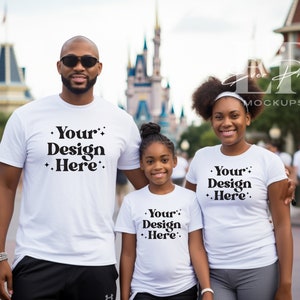 May include: A family of three wearing white t-shirts with the text "Your Design Here" printed on them. The family are standing in front of a castle-like building.