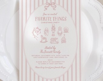 May include: A white invitation card with pink vertical stripes and text that reads "Favorite Things Christmas Party" is centered on a white scalloped plate. The invitation includes illustrations of toys and is decorated with a sprig of evergreen.