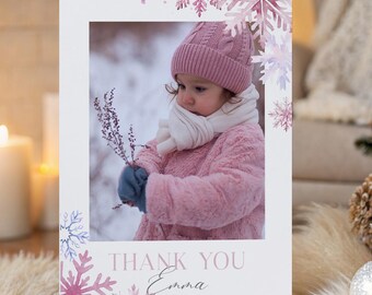 Puede incluir: Tarjeta de felicitación blanca con una foto de un niño con ropa de invierno, enmarcada por copos de nieve rosas. La tarjeta dice "THANK YOU Emma" en una escritura delicada, perfecta para expresar gratitud en invierno.