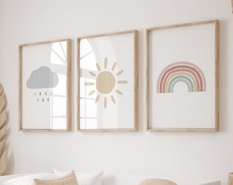 Puede incluir: Un sofá cama blanco con una manta acolchada beige y almohadas. Tres impresiones enmarcadas cuelgan de la pared sobre la cama. Las impresiones muestran un sol, un arcoíris y una nube con gotas de lluvia.
