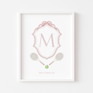 May include: A white framed print with a pink and white crest featuring the letter "M" and a pink ribbon. Two white tennis rackets and a green tennis ball are below the crest. The text "Marry Briana Ray" is at the bottom of the print.