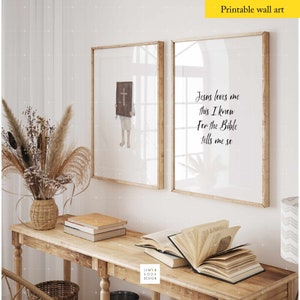 May include: Two framed prints with a Christian theme. The left print shows a person holding a Bible with a cross on the cover. The right print has the text "Jesus loves me this I know For the Bible tells me so".