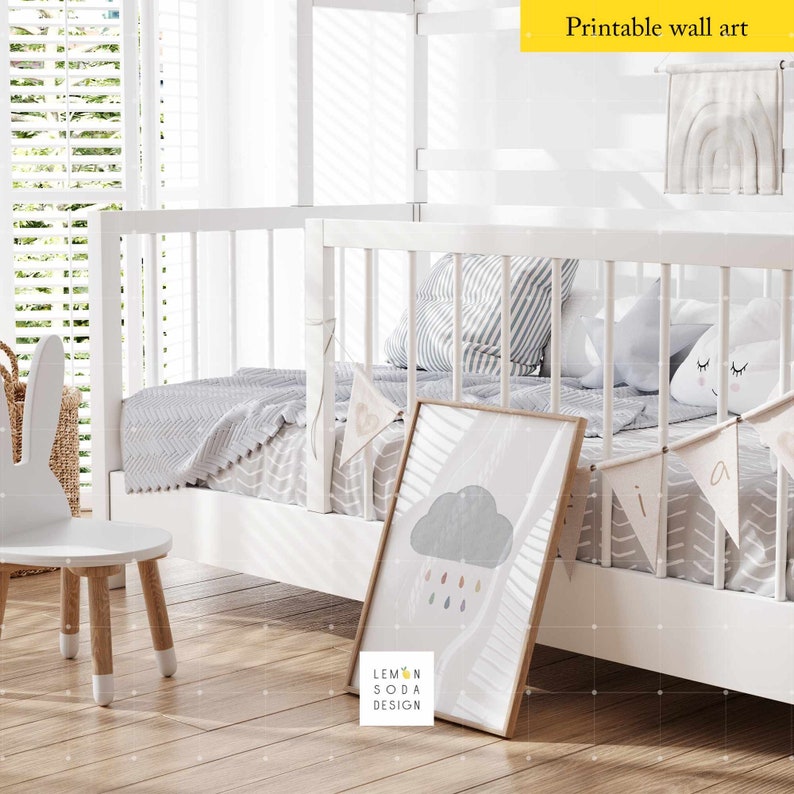 May include: White wooden bunk bed with a gray and white striped blanket, a gray cloud with raindrops print, and a white bunny chair. The bed has a white railing and a white headboard. The room has a white wall and a window with white blinds.