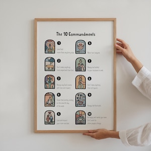 May include: A framed print titled "The 10 Commandments" with colorful illustrations and text. The print is in a light wood frame and features ten numbered commandments with accompanying images and text, including "Love God" and "Never hurt anyone."