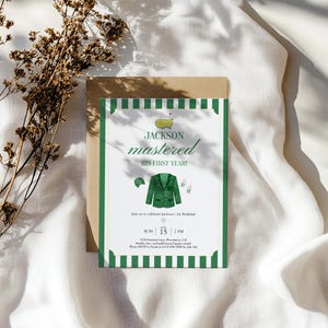 May include: A golf-themed invitation with a green and white striped border. The invitation features the text "Jackson mastered his first year!" and includes illustrations of golf-related items. The date and time are also included.
