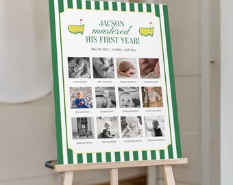 May include: A green and white striped sign on a wooden easel. The sign features the text "JACSON mastered HIS FIRST YEAR!" with a series of twelve small black and white photos. The sign also includes the date "May 5th 2022" and the weight "6LB 30oz".