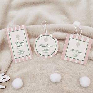 Könnte beinhalten: Drei Geschenkanhänger mit Golf-Motiv. Die Anhänger haben unterschiedliche Formen: rechteckig, quadratisch und kreisförmig. Jeder Anhänger hat einen rosa-weiß gestreiften Hintergrund, einen grünen Rand und die Worte "Thank you" in eleganter Schrift. Die Anhänger enthalten auch den Text "RENEE'S FIRST BIRTHDAY 05.15020XX".