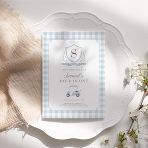 May include: A light blue and white gingham patterned invitation with the text "Let's Par-Tee for Samuel's Hole in One." The invitation features a golf cart illustration and a crest with the letter "S".