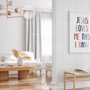 May include: A white couch with a wooden coffee table in front of it. The wall behind the couch has a framed print with the text "Jesus Loves Me This I Know" in colorful letters.