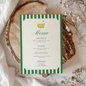 May include: A menu card with a green and white striped border and a green frame. The menu features the word "Menu" at the top, followed by "Appetizer," "Entrée," and "Dessert." The menu includes a logo of a golf course.