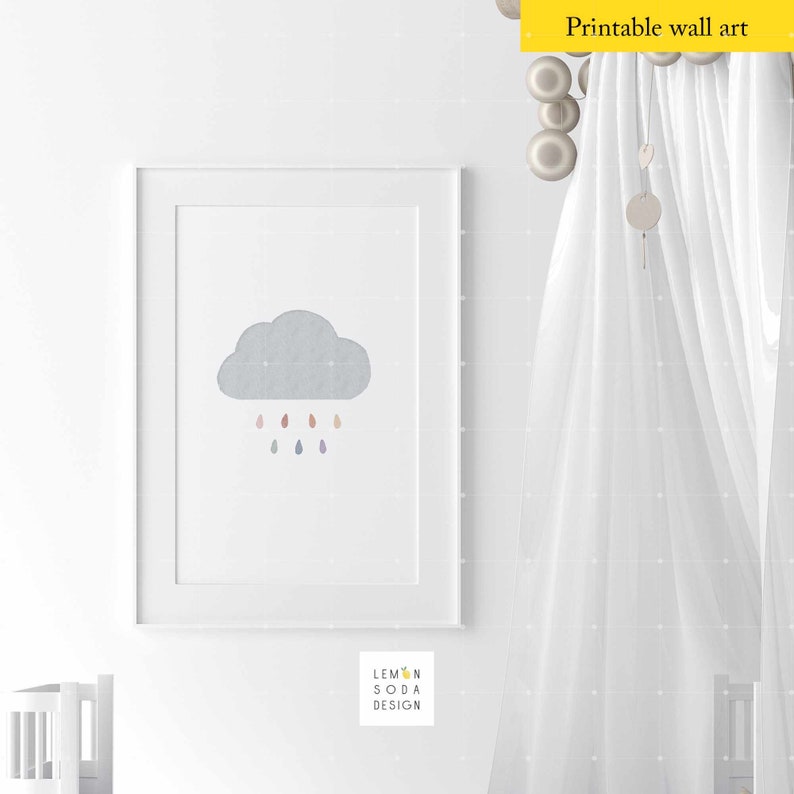 May include: A printable wall art print featuring a gray cloud with colorful raindrops. The print is framed in a white frame and is displayed on a white wall. The text "Lemon Soda Design" is visible in the bottom right corner of the image.
