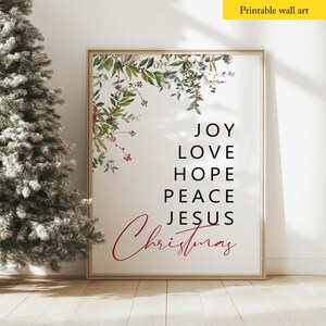 May include: Printable wall art with a watercolor floral design in shades of green and red. The text reads "Joy Love Hope Peace Jesus Christmas".