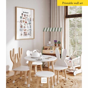 May include: A children's playroom scene featuring a framed "Bible Alphabet" print, a small white table with chairs, and a wooden market stand. The chairs have unique designs, including bunny ears and antler shapes. The room is decorated with neutral tones and natural materials.