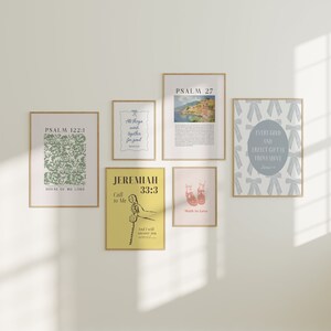 May include: A collection of six framed prints featuring religious quotes and images. The prints are in a variety of colours and styles, including a yellow print with a telephone, a pink print with shoes, and a blue print with a cityscape.