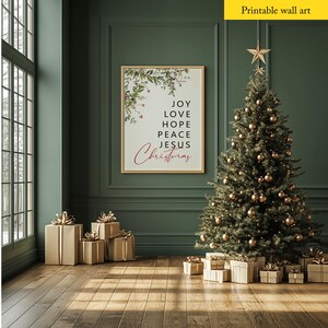 May include: Printable wall art featuring a Christmas-themed design with a green background and a white frame. The text reads "Joy Love Hope Peace Jesus Christmas".