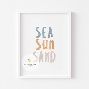 Pu&ograve; includere: Una stampa incorniciata bianca con le parole "SEA SUN SAND" in stile acquerello. Le parole sono in diverse tonalit&agrave; di blu, arancione e marrone. Un piccolo limone con una foglia verde si trova nell'angolo in basso a sinistra.