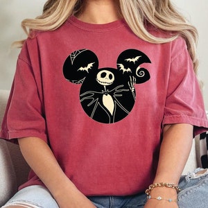 May include: A maroon t-shirt with a black Mickey Mouse silhouette featuring Jack Skellington from The Nightmare Before Christmas.
