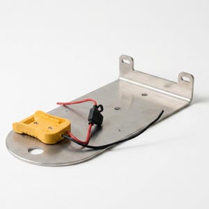 Puede incluir: Una placa de montaje de metal cepillado con un extremo curvo que presenta un orificio circular, un soporte trasero en ángulo con dos ranuras y un conector eléctrico amarillo unido por cables rojo y negro con un pequeño portafusibles negro.
