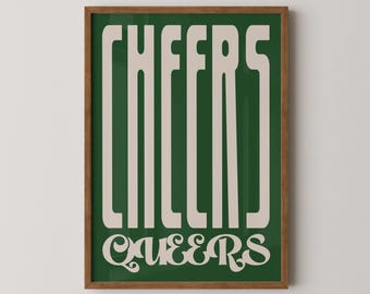 May include: A framed print with a green background and white text that reads "CHEERS QUEERS" in a retro font.