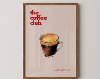 May include: A framed poster with a pink background and the text "the coffee club." in red. A watercolor illustration of a cup of coffee with a brown handle is in the center of the poster. The text "fresh coffee every morning from 7am" is at the bottom of the poster.