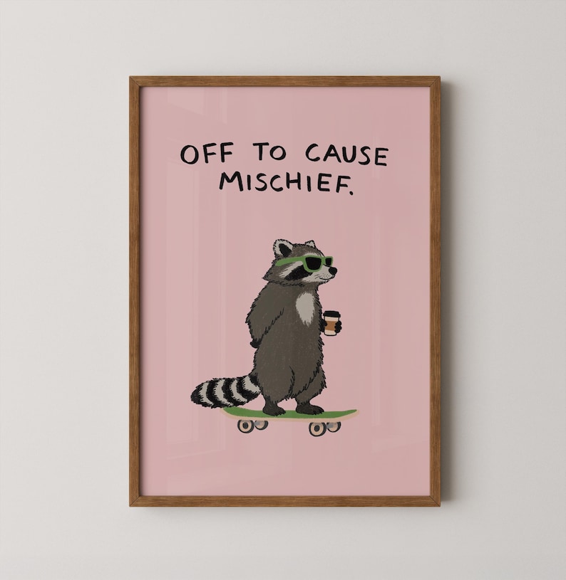 Puede incluir: Impresi&oacute;n enmarcada con un mapache de dibujos animados con gafas de sol y una taza de caf&eacute;, sobre una patineta. El mapache es gris y blanco, sobre un fondo rosa con el texto "OFF TO CAUSE MISCHIEF."