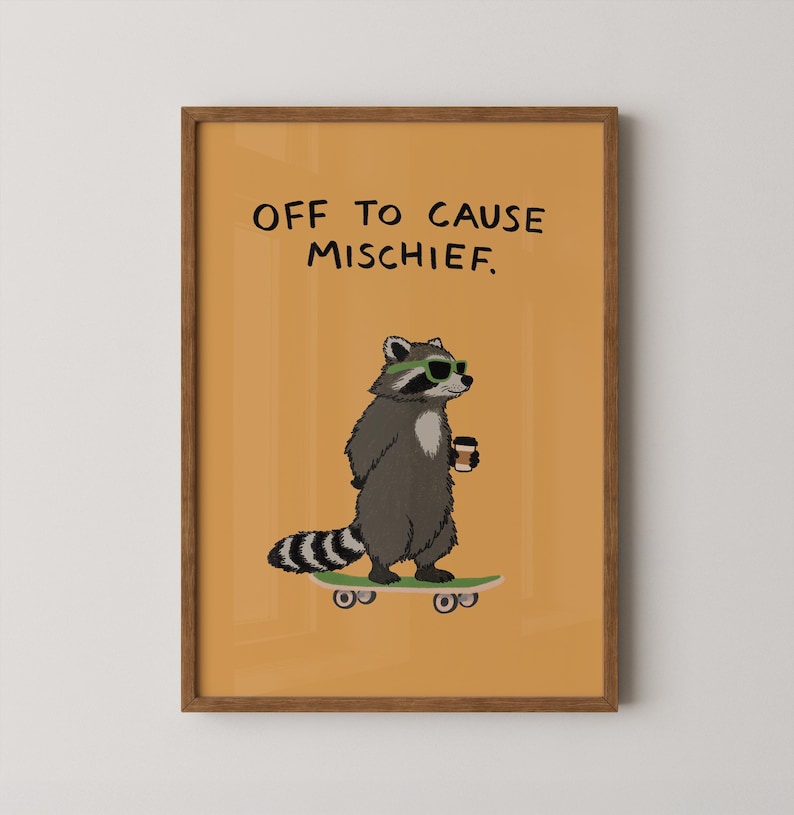 Puede incluir: Impresi&oacute;n art&iacute;stica enmarcada con un mapache de dibujos animados con gafas de sol y una taza de caf&eacute;, de pie sobre una patineta. La impresi&oacute;n tiene el texto "OFF TO CAUSE MISCHIEF" sobre un fondo naranja.