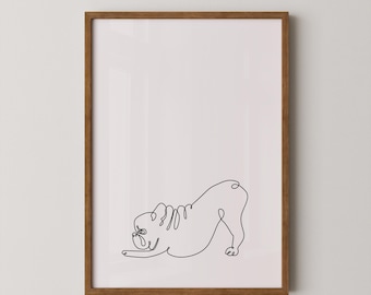 May include: A framed print of a line drawing of a bulldog in a playful pose. The print is on a white background and is framed in a light brown wood frame.