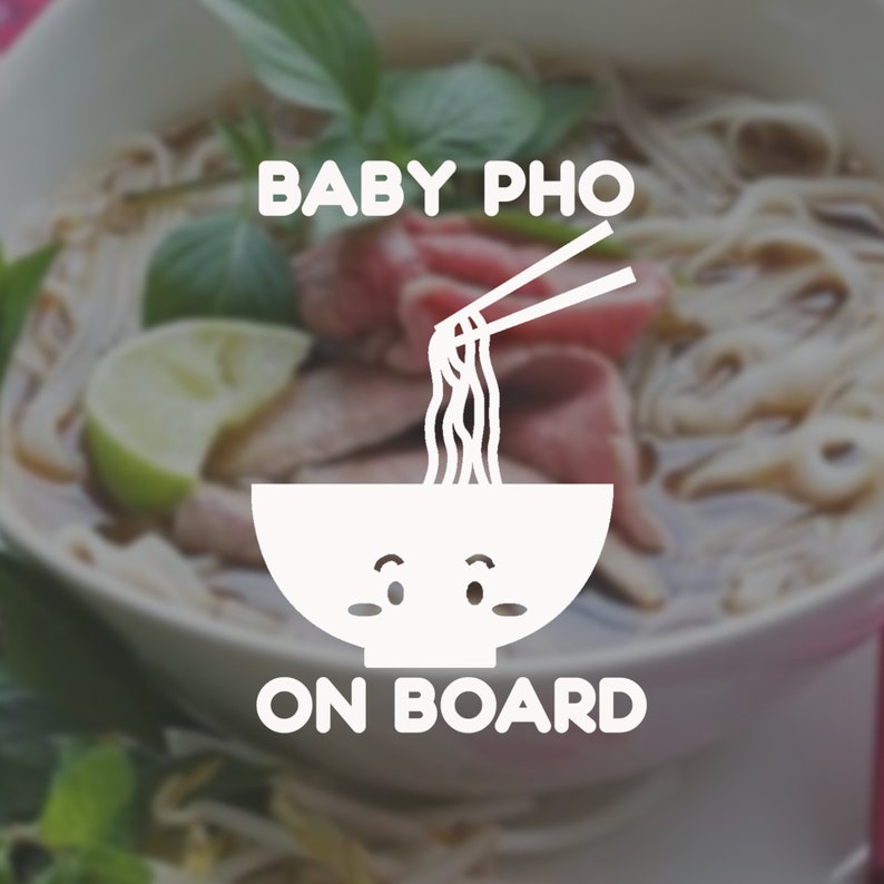May include: A white cartoon bowl with a face and chopsticks holding noodles. The text "BABY PHO ON BOARD" is below the bowl. The bowl is in front of a blurry image of a bowl of pho.