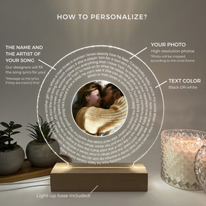 May include: A customisable night light with a photo and song lyrics. The clear acrylic disc has a central photo and encircling lyrics. It rests on a wooden base with a light-up feature. Text can be black or white. The base is included.