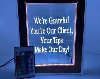 Hucha LED personalizada de 18 cm de ancho x 21,5 cm de alto. 16 colores LED y control remoto. Incluye logotipo, foto y código QR. Ideal para DJs, bármanes, eventos y artistas.
