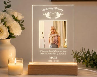 May include: A rectangular acrylic plaque with a light-up wooden base featuring a photo of a person. The text reads In Loving Memory, Wherever a beautiful soul has been, there has been a trail of memories, MOM, and 1947-2020.