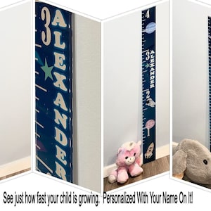 May include: A blue and white personalized growth chart with a space theme. The chart features a rocket, planets, and stars. The name "ALEXANDER" is printed on the chart.