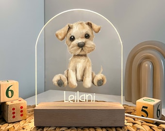 Puede incluir: Una luz nocturna de acrílico blanco con forma de arco con una ilustración de un perro de dibujos animados lindo y el nombre "Leilani" impreso debajo. La luz nocturna está sentada sobre una base de madera.