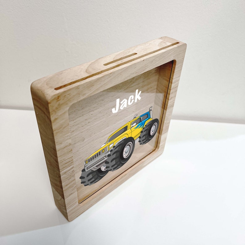 May include: A wooden frame with a clear acrylic insert featuring a cartoon monster truck and the name "Jack".