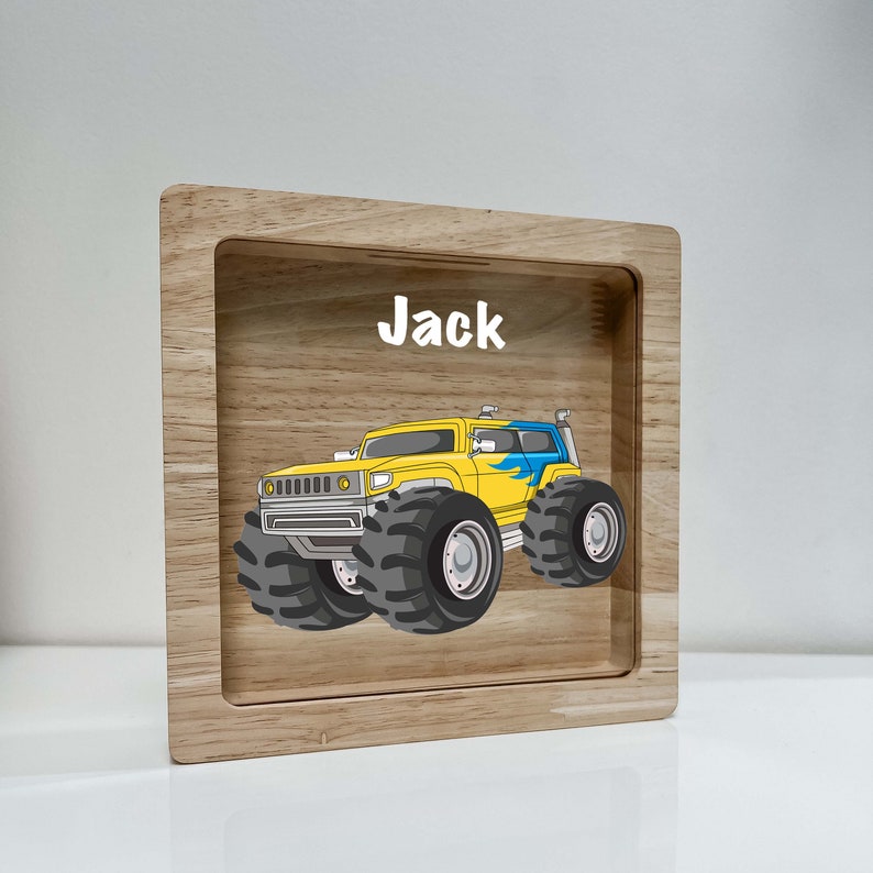 May include: A wooden tray with a yellow monster truck design and the name "Jack" printed on it.