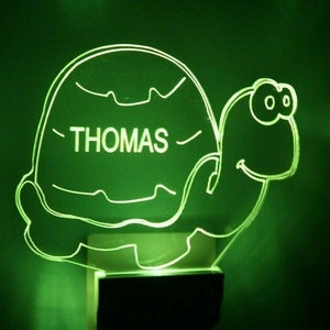 May include: Green night light shaped like a turtle with the name "THOMAS" written on the shell.