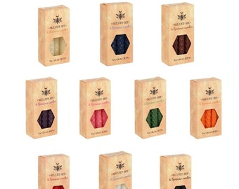 May include: A set of 10 boxes of beeswax candles, each box containing 6 candles. The candles are in various colors, including white, black, red, orange, green, purple, and pink. Each box has a label that reads "Blessed Bee" and "6 beeswax candles".