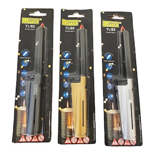 May include: Three Clipper Tube candle lighters in black, gold, and silver packaging. Each lighter features a long, thin nozzle and a refillable butane tank. The packaging includes the Clipper logo and the words "Tube Candle Lighter".