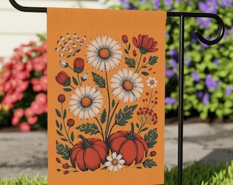 May include: Orange garden flag featuring a floral design with white daisies, red flowers, and orange pumpkins. The flag is displayed on a black metal stand, perfect for outdoor decor. The flag has the text "Fuck Trump".