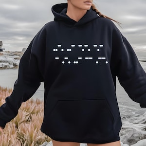 May include: Black hooded sweatshirt with a white design of the word "LOVE" written in braille.