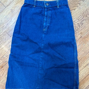 May include: A dark blue denim skirt with a button closure and a high waist.